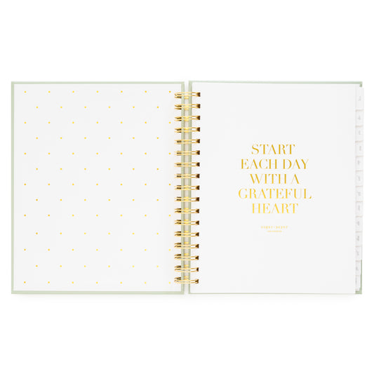 Open planner with polka dot page and 'start each day with a grateful heart' in gold foil on white background
