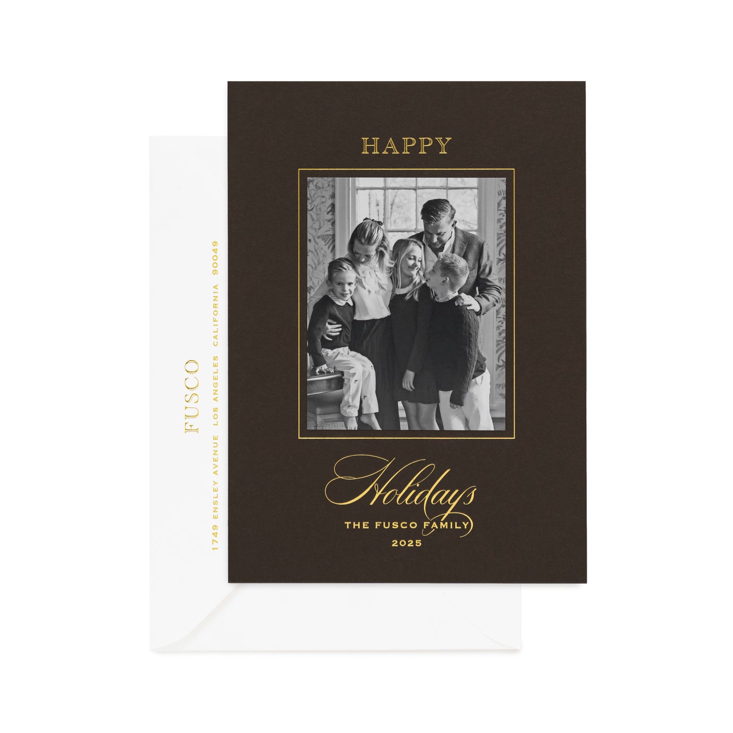 Chocolate brown custom holiday photo card with black and white family photo and gold foil greeting 'happy holidays the fusco family 2025' paired with a white envelope with gold foil address