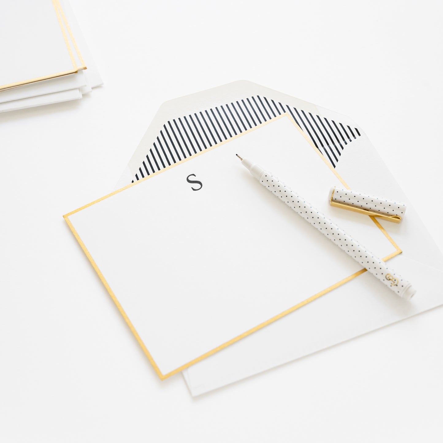 monogram note note with a black S initial, gold hand painted border and black stripe envelope liner