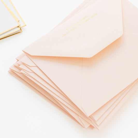 Stack of pale pink envelopes with sugar paper logo embossed