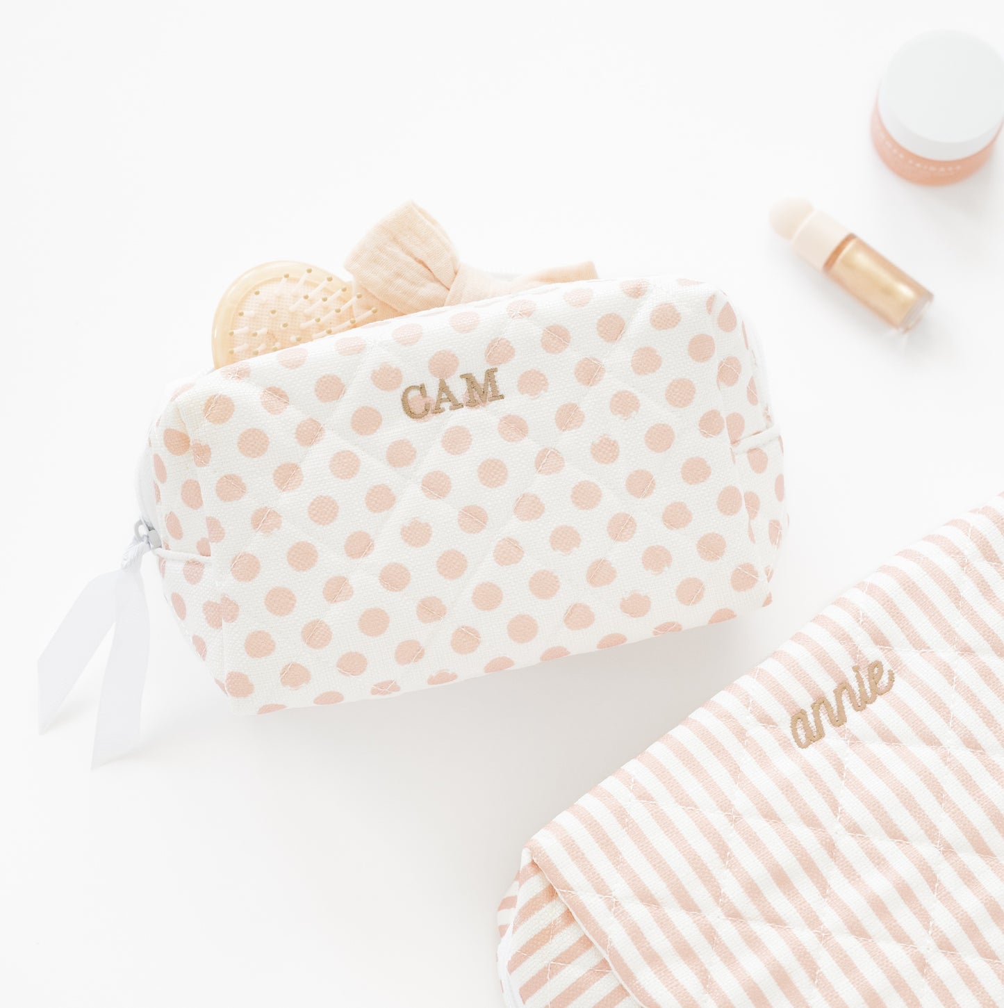 Rose and white cosmetic pouches embroidered with tan thread
