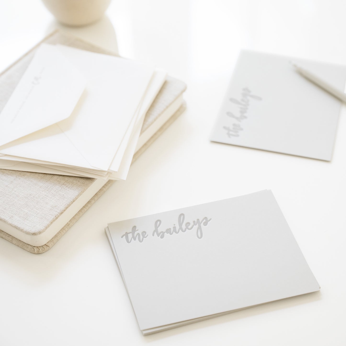 Stack of grey flat stationery cards with 'the baileys' paired with white envelopes