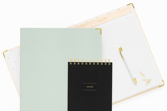 assorted office products in pink, mint green and black with gold accents