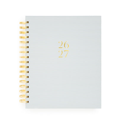 Blue stripe spiral planner with 26 27 in gold foil on the cover and a gold spiral binding