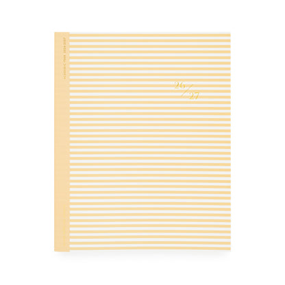 Yellow and white striped planner with '26 27' in gold foil on cover with yellow tape binding
