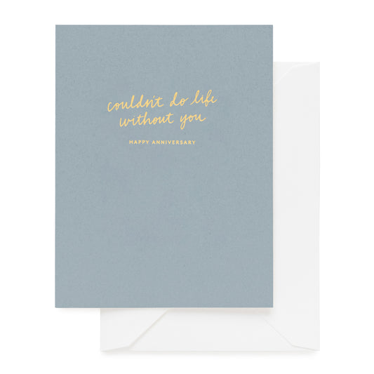 Blue card with gold text 'what is grief if not love persevering happy anniversary' paired with a white envelope