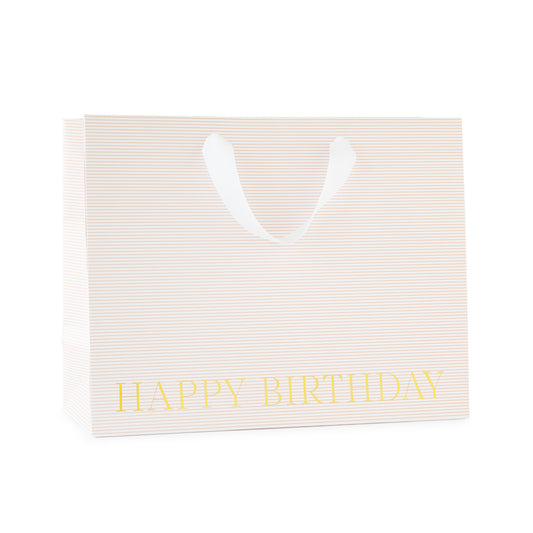 large gift bag with white ribbon handles with a pink stripe pattern printed with happy birthday in gold foil