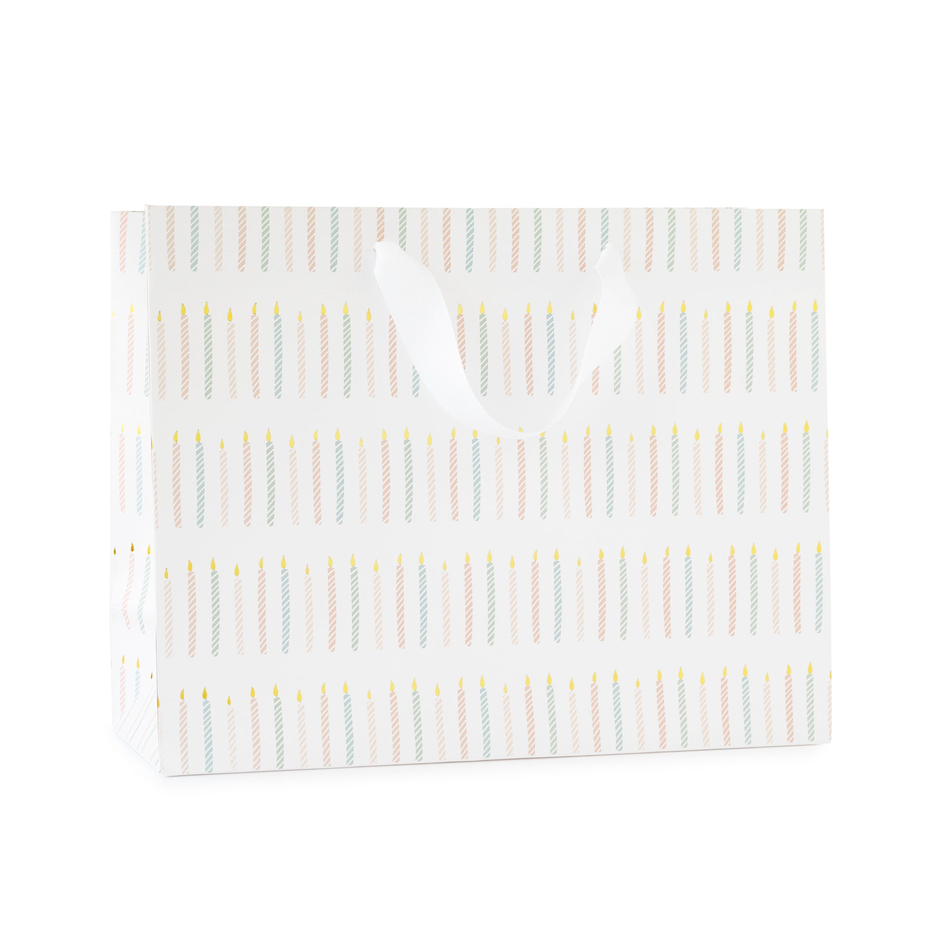 large gift bag with white ribbon handles printed with a colorful candle pattern in pink and blue with gold foil