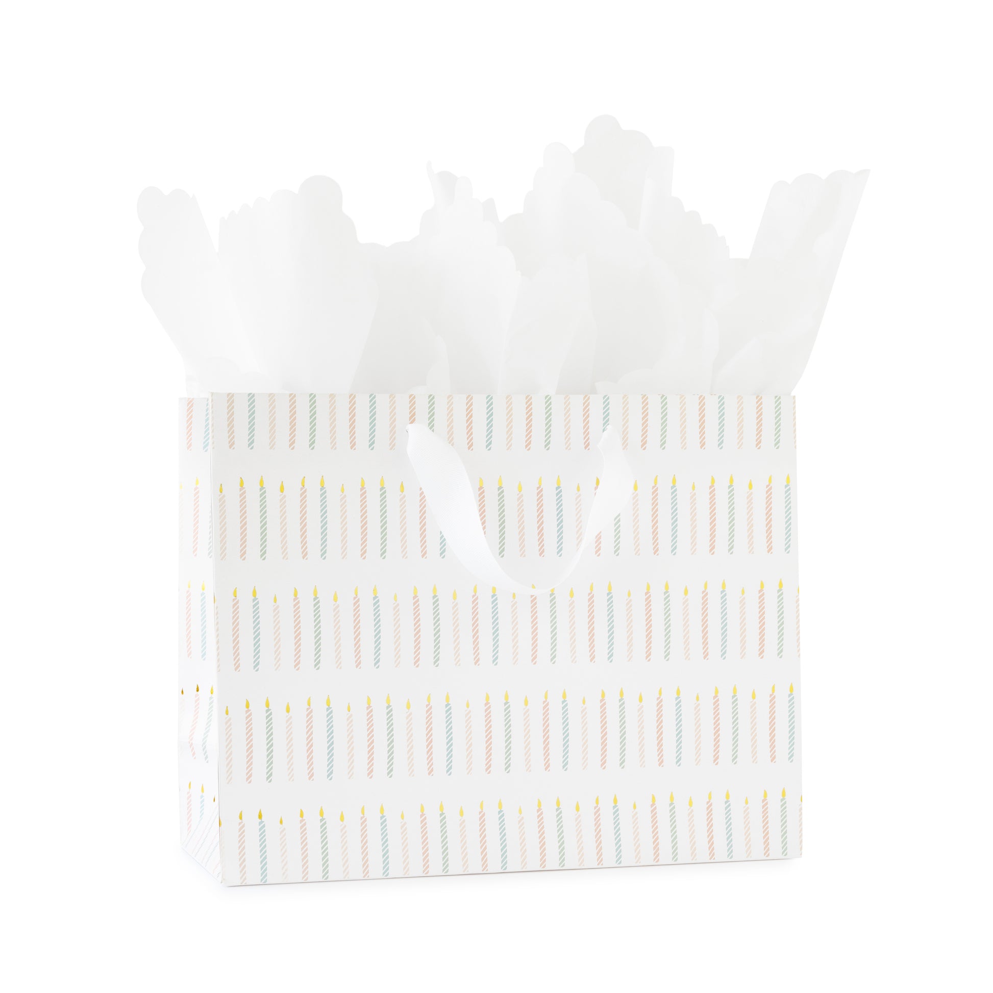 large gift bag with white ribbon handles printed with a colorful candle pattern in pink and blue with gold foil with white scallop tissue paper