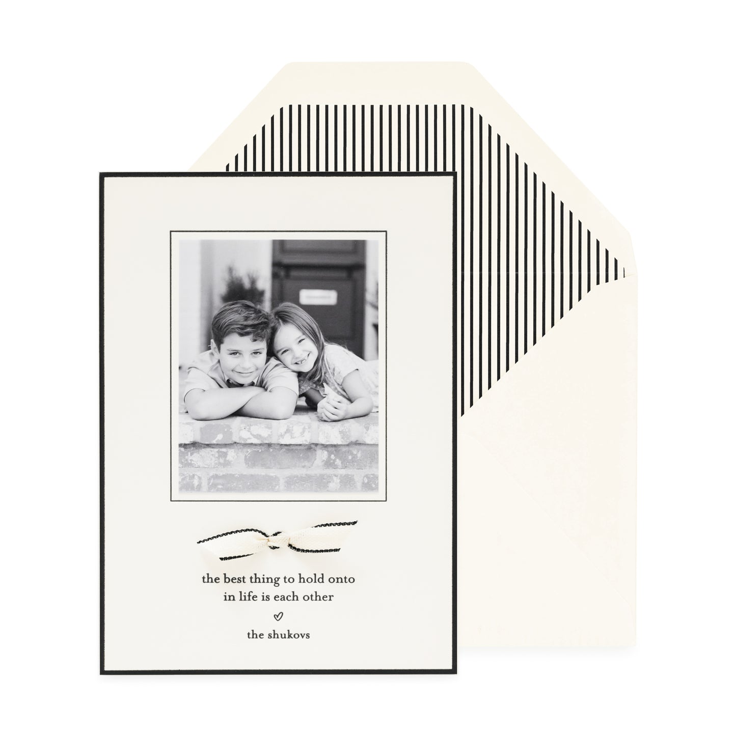 cream and black custom holiday card with ribbon detail and striped liner