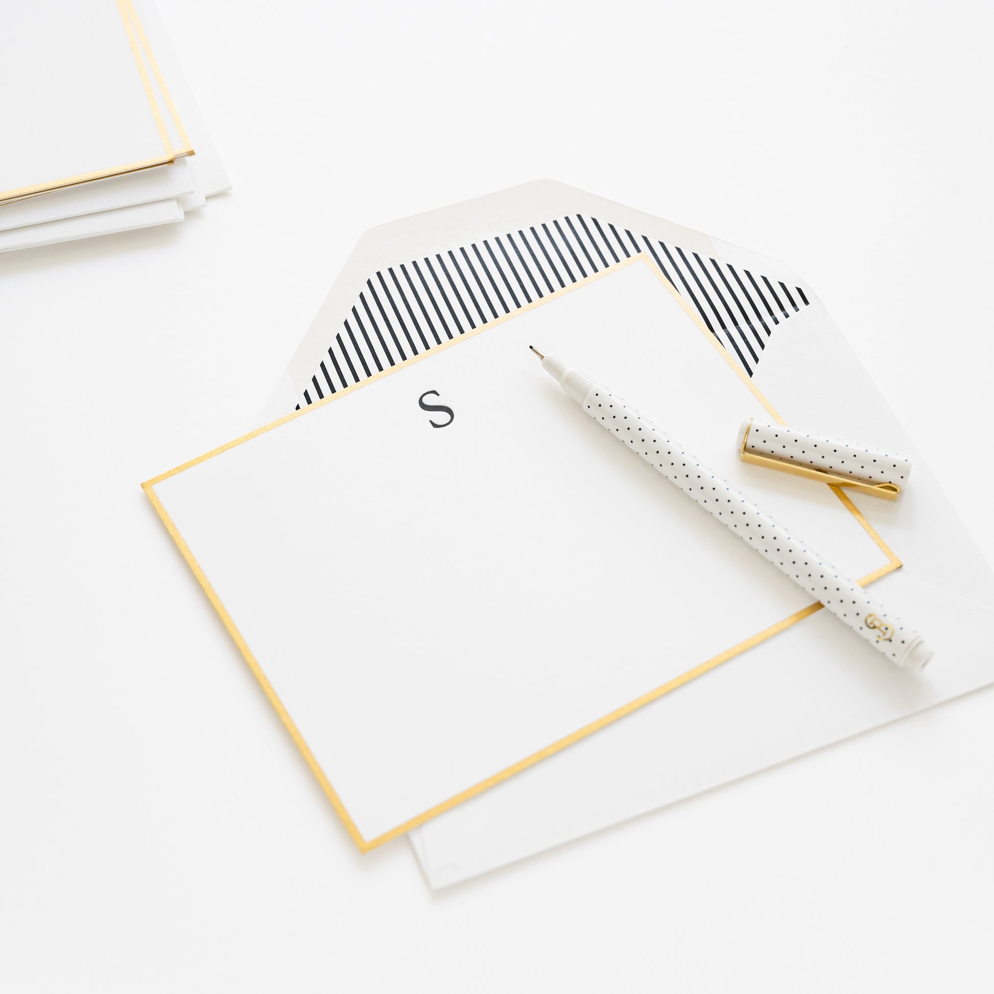 monogram note note with a black S initial, gold hand painted border and black stripe envelope liner