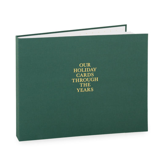 Dark green holiday card spiral bound fabric book with 'our holiday cards through the years' on cover