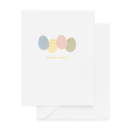 White greeting card with pink, blue, yellow and green Easter eggs and 'happy Easter' in gold foil with a white envelope