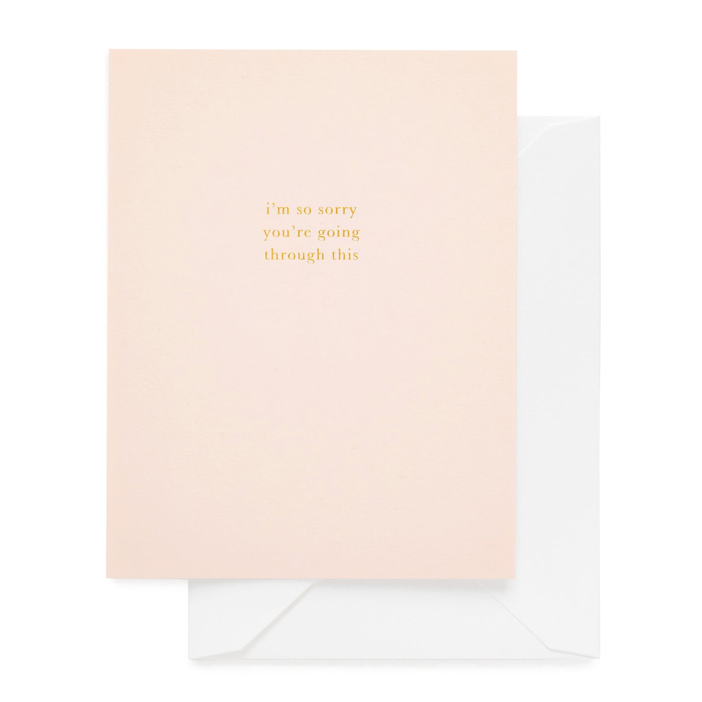 Greeting card with 'I'm so sorry you're going through this' text in gold foil on pink paper with white envelope