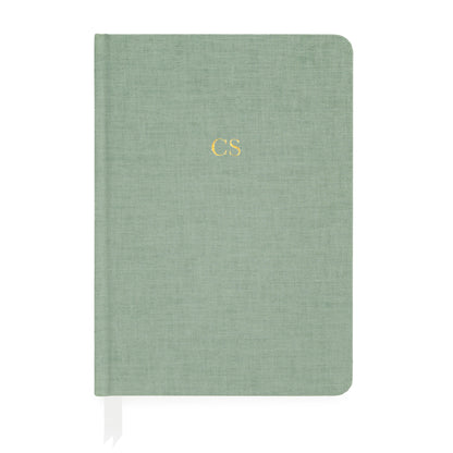 Sage green fabric journal with white ribbon markers foil stamped with gold initials
