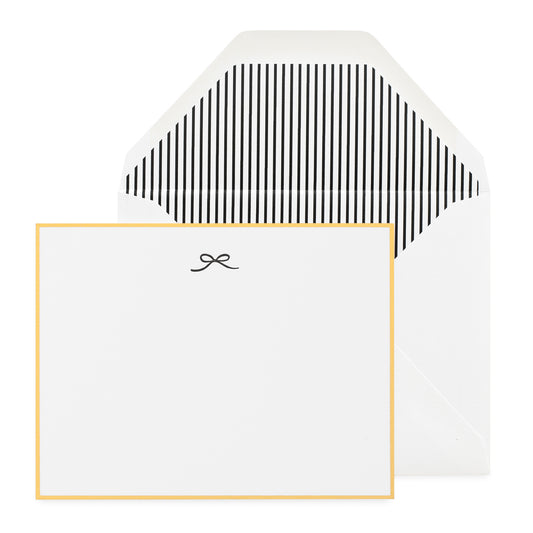 white card with black bow icon and gold border, white envelope with black pinstripe liner