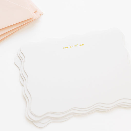 Personalized white notecards with scalloped edge with 'kate hamilton' in gold foil paired with pink envelopes