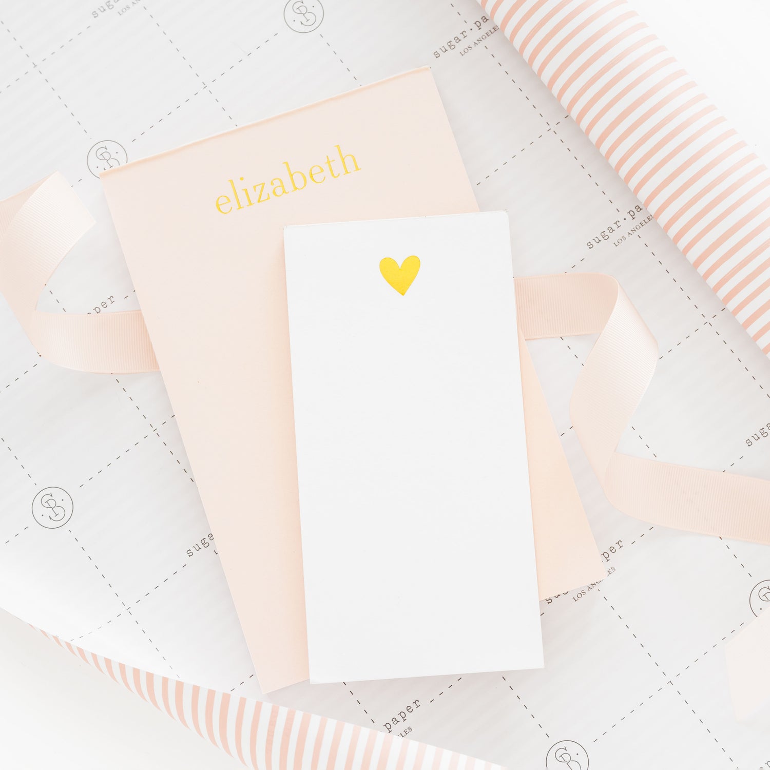 Personalized notepad with name 'elizabeth' and a notepad with heart design on gift wrap.
