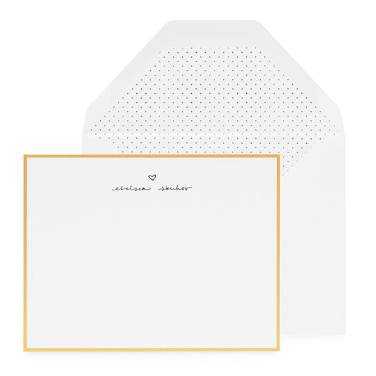 gold bordered custom stationery card with black letterpress ink with script name and heart and black pindot liner in white envelope