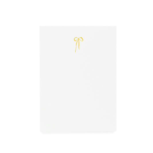 White notepad with gold hand drawn bow foil printed on it