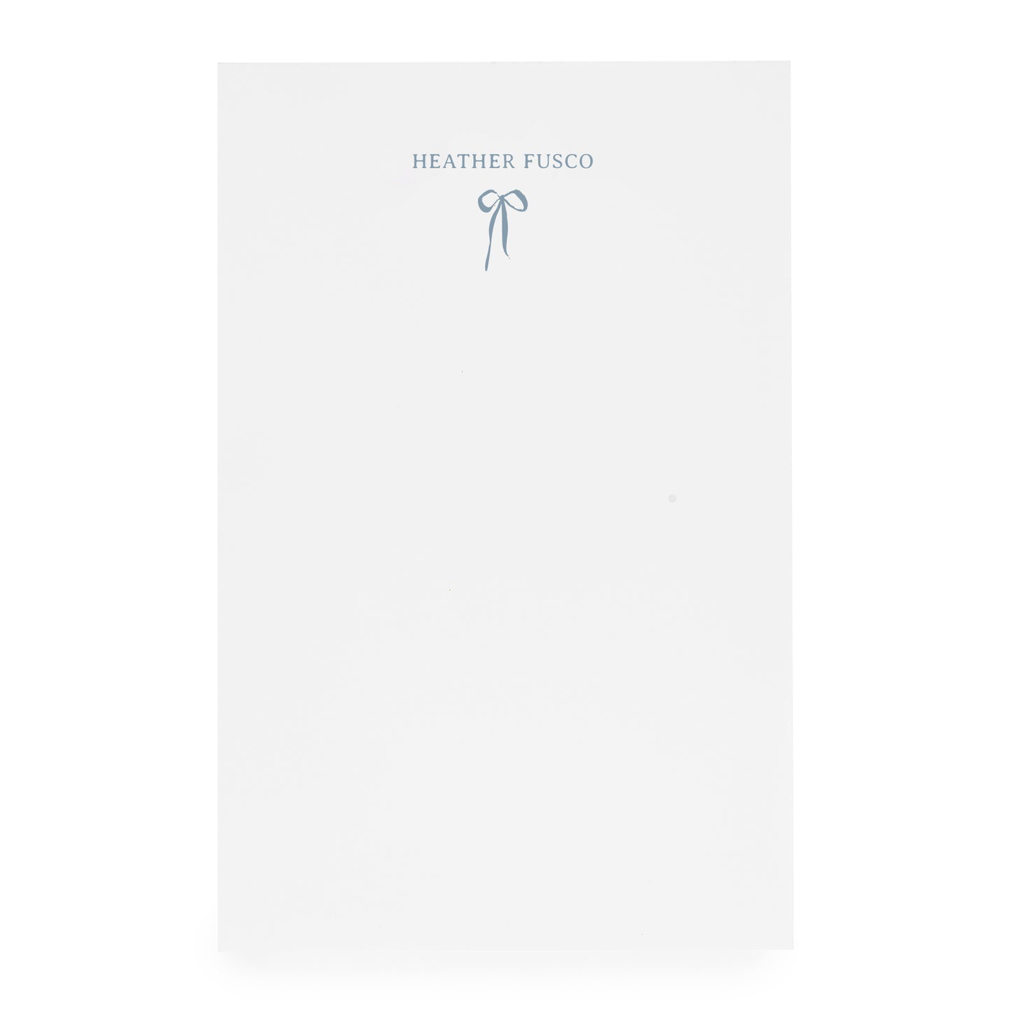 White notepad with ribbon bow and "heather fusco" in blue ink