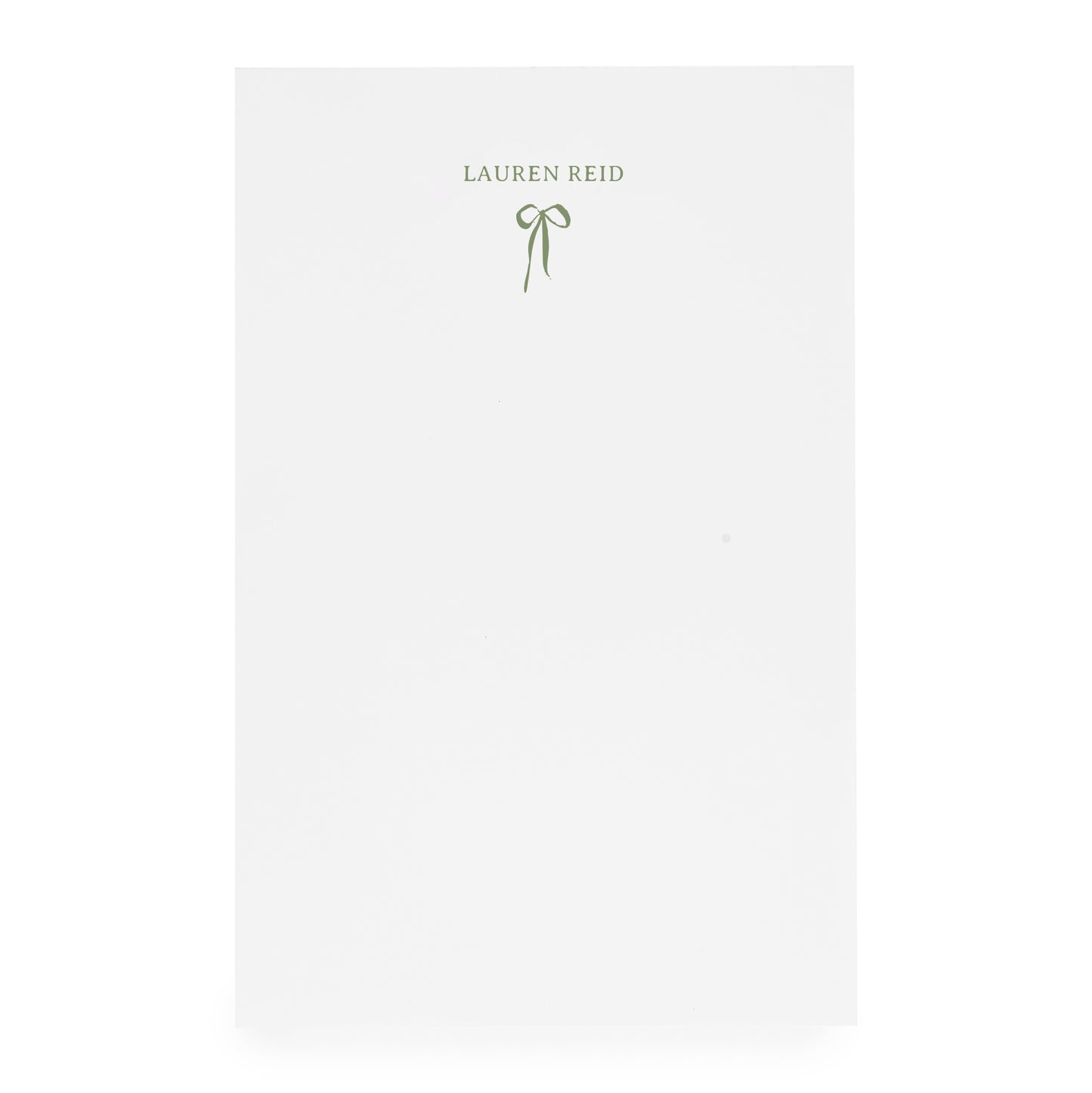 White notepad with ribbon bow and "lauren reid" in moss green ink