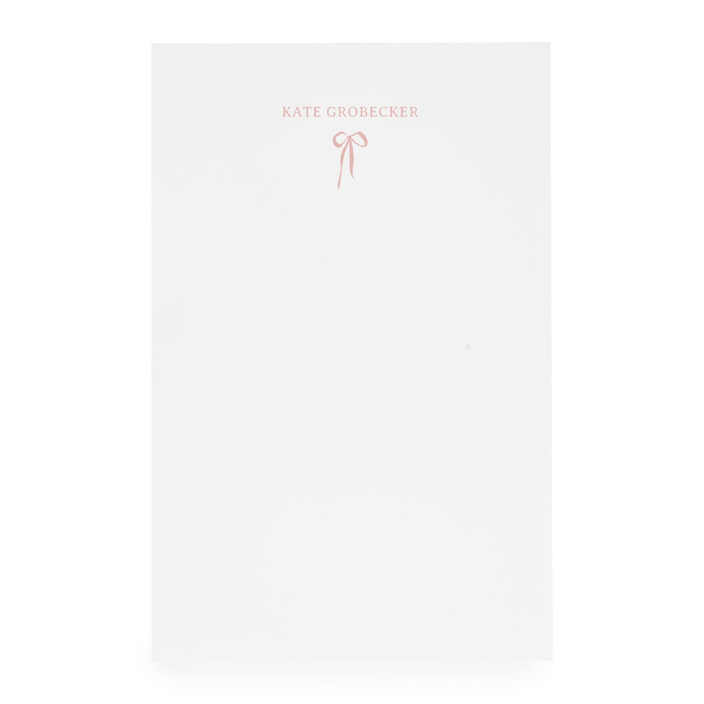 White notepad with pink bow and "kate grobecker" in pink