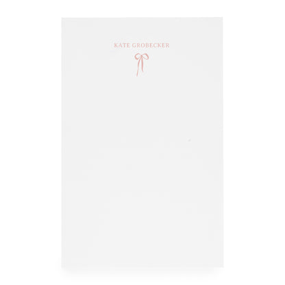 White notepad with pink bow and "kate grobecker" in pink