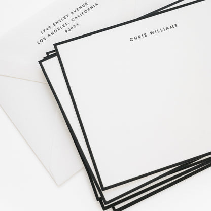 Stack of black bordered flat stationery cards with 'chris williams' and address on the envelope