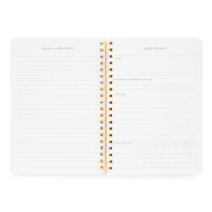 Interior of goal tracker spiral notebook with space for "notes and reflections" and goal tracker with "goal, motivated to accomplish this because, action plan and habits that help" sections.