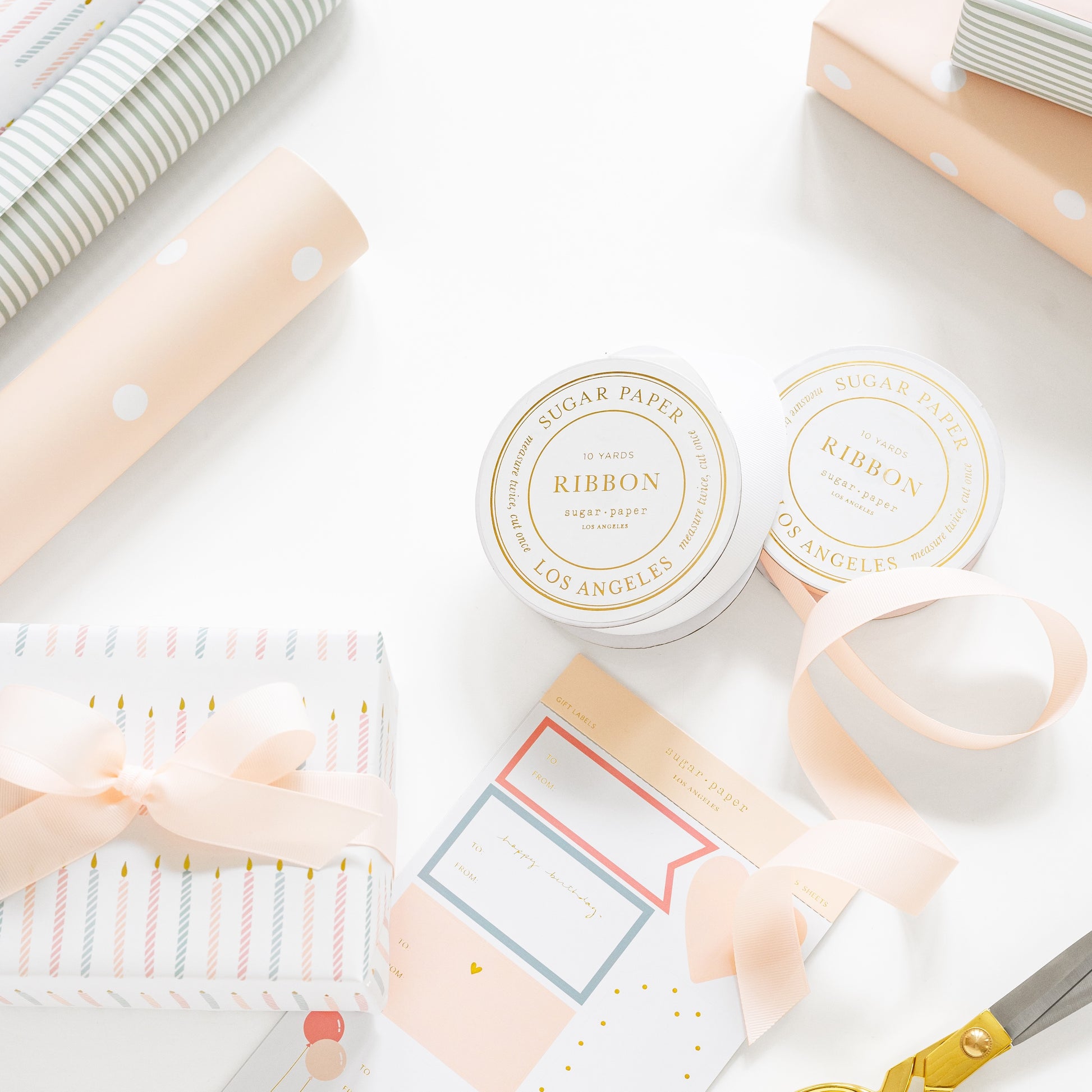 ribbon spools, gift tag stickers, and wrapping paper with a wrapped gift