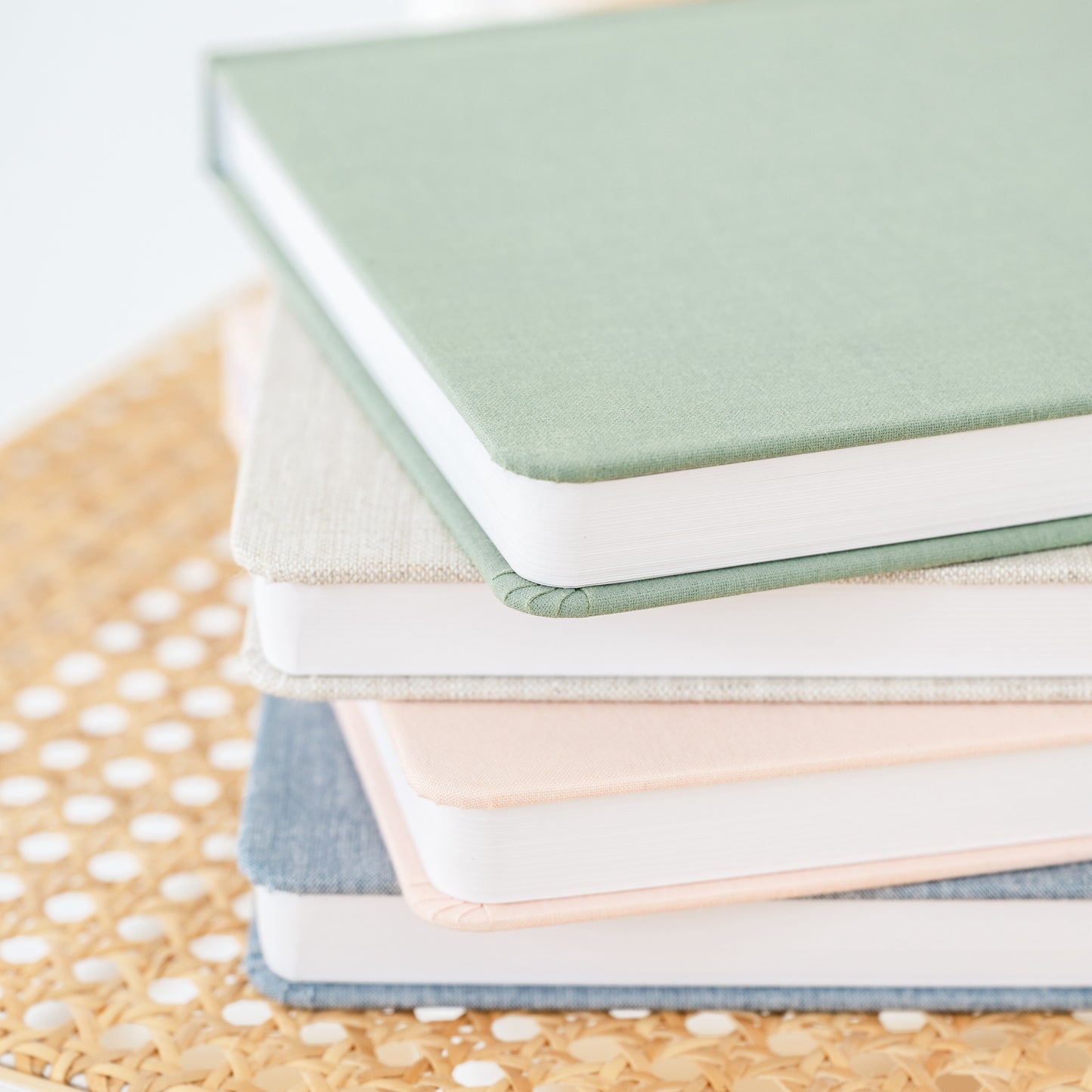 Stack of undated planners in green, flax, pink, and chambray