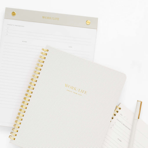 spiral notebook on top of a guided notepad and a guided notebook