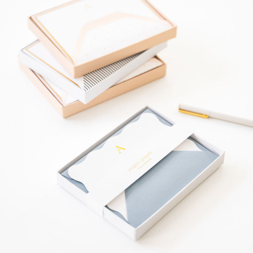 Boxes of stationery and a pen, on a white surface.