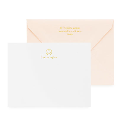 white card with gold foil smiley and text, pale pink envelope