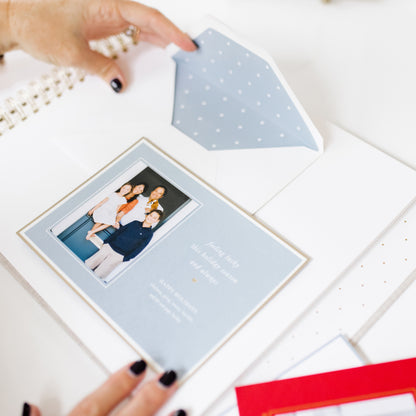 person adhering a holiday card into the holiday card book